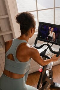 bicicleta de spinning Mulher se exercitando numa bicicleta de spinning em casa.